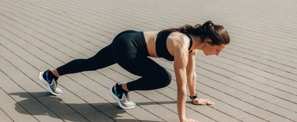 Woman in black sportswear doing an outdoor workout on a sunny day.