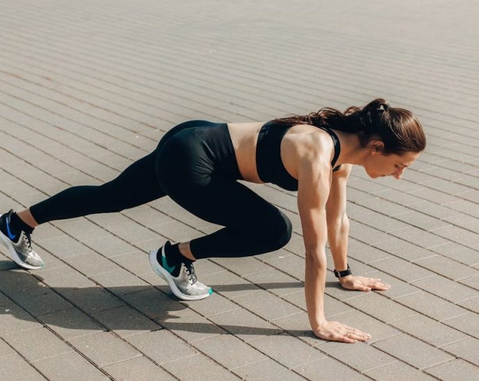Woman in black sportswear doing an outdoor workout on a sunny day.
